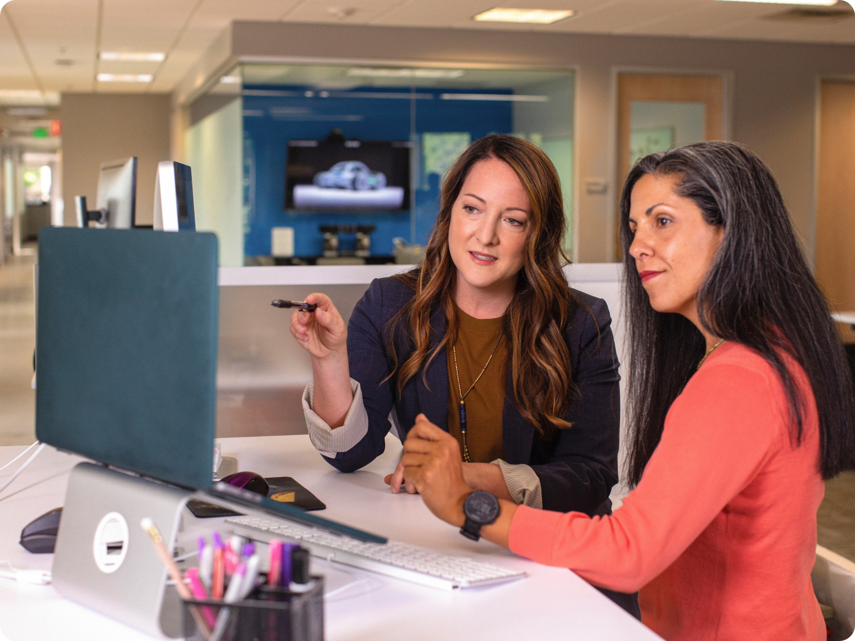 Two women having a conversation while looking at a computer screen