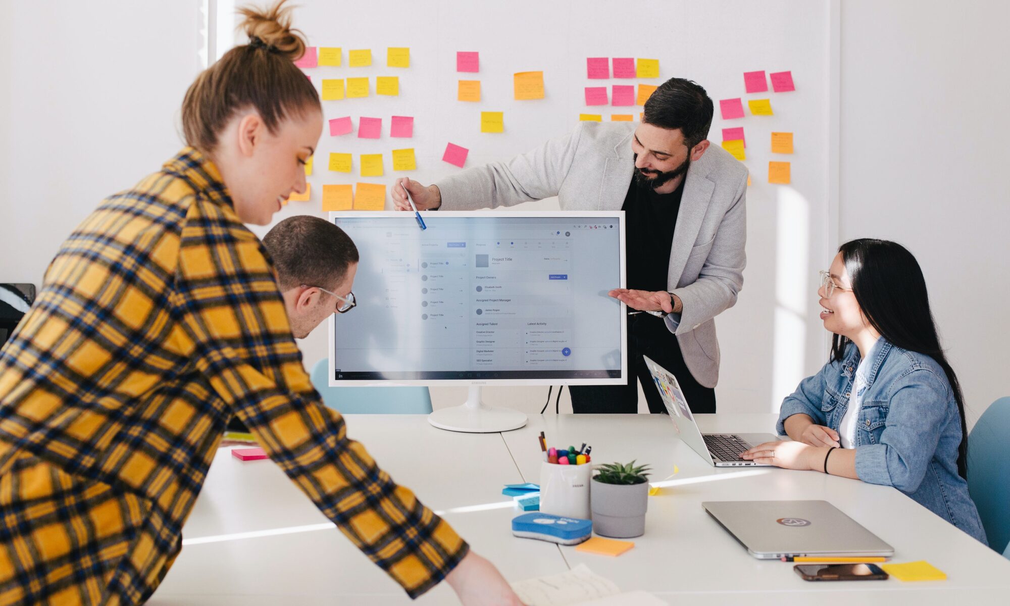 Group of people conducting a workshop with a whiteboard and coloured paper